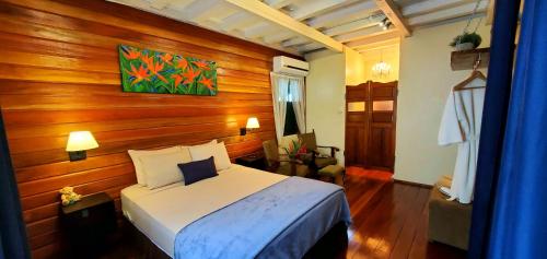 帕拉马里博Prins Hendrik Suites的一间卧室设有一张床和木墙
