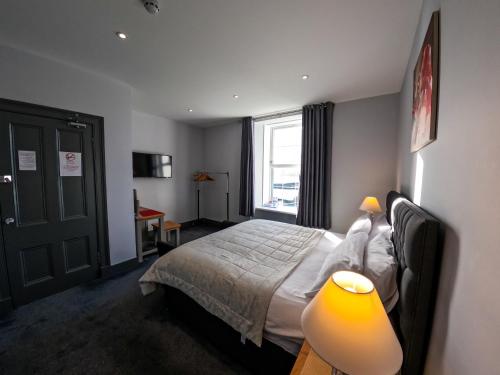 勒威克Maryfield House Hotel的一间卧室配有一张带灯和窗户的床