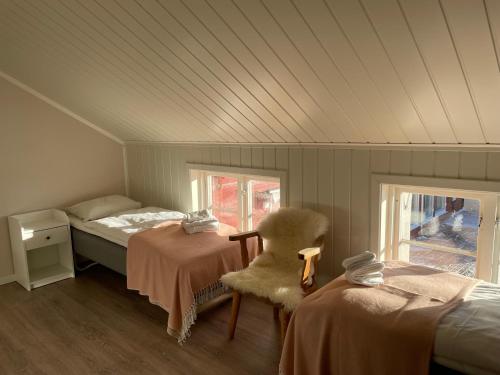 诺德塞特Lillehammer Fjellstue og Hytteutleie的一间卧室设有两张床、一把椅子和一个窗户。