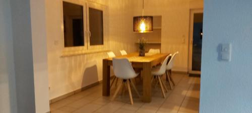 比特堡Ferienwohnung KaMa的餐桌、白色椅子和灯