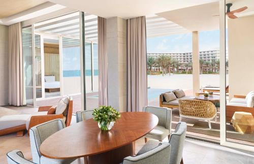 拉斯阿尔卡麦InterContinental Ras Al Khaimah Mina Al Arab Resort & Spa, an IHG Hotel的一间带桌椅和海滩的用餐室