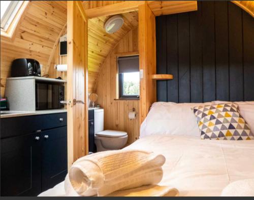 基斯Robins Nest Glamping Pod with Hot Tub的小木屋内一间卧室,配有一张床