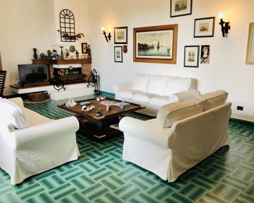 卡普多兰多Villa Luigina - seafront villa in Capo d'Orlando的客厅配有白色沙发和咖啡桌