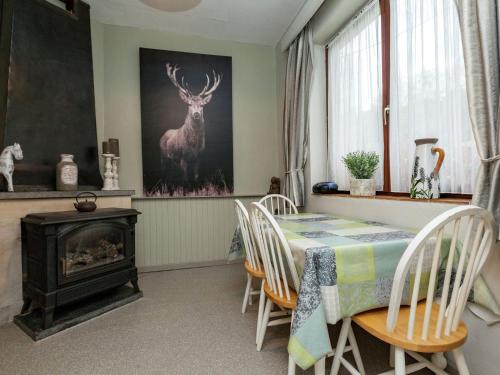 马尔梅迪Holiday Home in Malmedy with terrace的用餐室配有桌子,墙上挂着鹿画