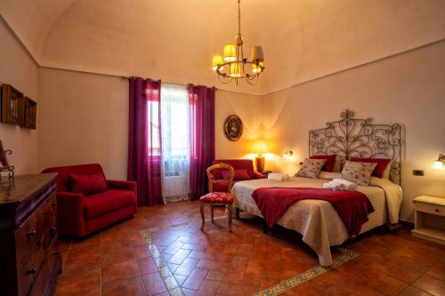 马萨鲁布朗斯Agriturismo Il Convento的一间卧室配有一张床和一张红色椅子