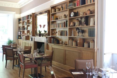 斯通豪斯弗洛塞斯特酒店的用餐室配有桌椅和书架