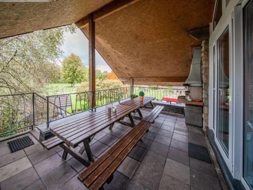 韦姆Charming cottage with jacuzzi and sauna High Fens的阳台的门廊设有2张木制长椅