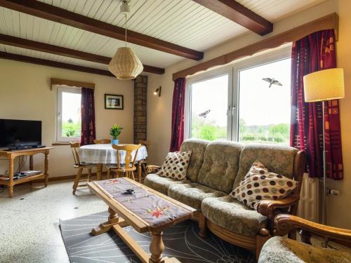 希尼Quaint Cottage in Chiny with Private Garden的客厅配有沙发和桌子