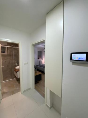 图兹拉Sun Square Apartments的客房设有一间墙壁上配有电视的浴室。