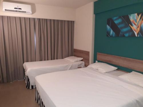 奥林匹亚Solar das Águas - Resort Em Olimpia - Ap 2 quartos的酒店客房设有两张床和绿色的墙壁。
