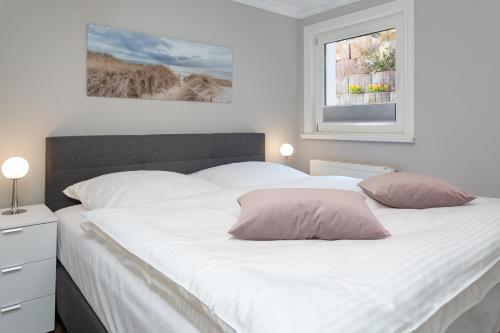 文尼斯塔特Strandhüs Family的卧室配有一张带两个枕头的大白色床