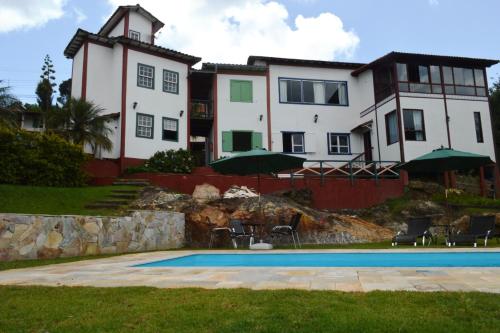 拉夫拉斯诺瓦斯Pousada Villa Verde的一座大房子,前面设有一个游泳池