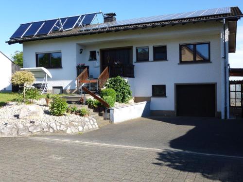 ÜxheimApartment in Leudersdorf Eifel with terrace的屋顶上设有太阳能电池板的房子