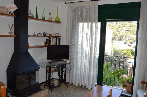 塔马留La Caseta的客厅设有壁炉和电视。