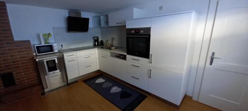 瓦尔德阿尔贝格Ferienwohnung Evi的小厨房配有白色橱柜和微波炉