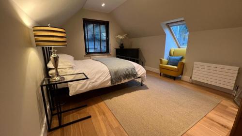 邓布兰NEW 1BD Contemporary Flat Upper Dunblane的一间卧室配有一张床、一张桌子和一把椅子