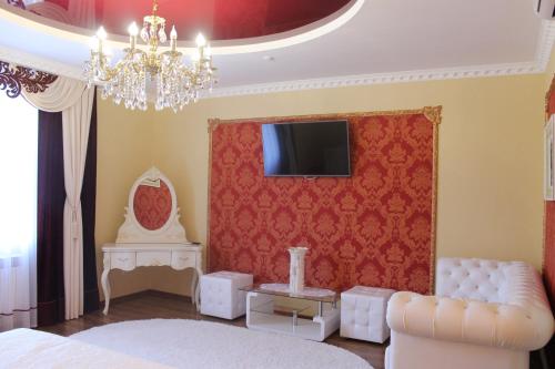 赫梅利尼茨基所博科夫酒店的一间带沙发的卧室和墙上的电视