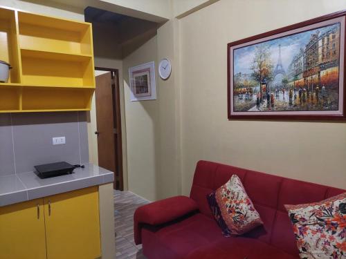 马尼拉bluenest apartment的客厅配有红色的沙发和墙上的绘画