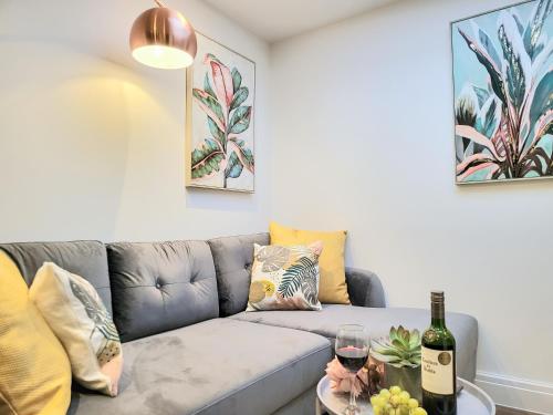 布莱顿霍夫Luxury pad centrally located near Brighton station的客厅配有沙发和一杯葡萄酒