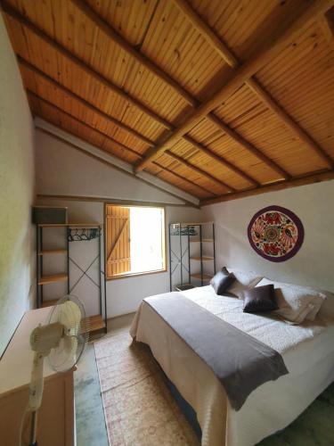 西波山Casa da Rê的一间卧室设有一张大床和木制天花板