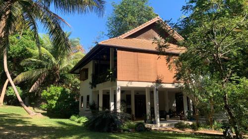 俊穆岛VillaVarin Ko Jum - Nature, Space & Luxury的棕榈树庭院中间的房子