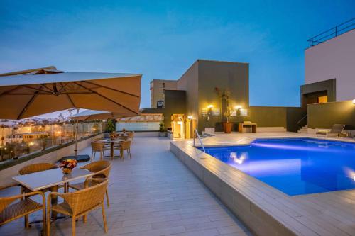 利马爱尔欧里瓦索尼斯塔酒店的一个带游泳池和桌椅的屋顶露台