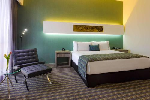 阿雷基帕Sonesta Hotel Arequipa的配有一张床和一把椅子的酒店客房