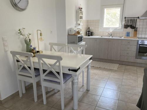 卢特拉Stylish Villa in Loutra的厨房配有白色的桌椅