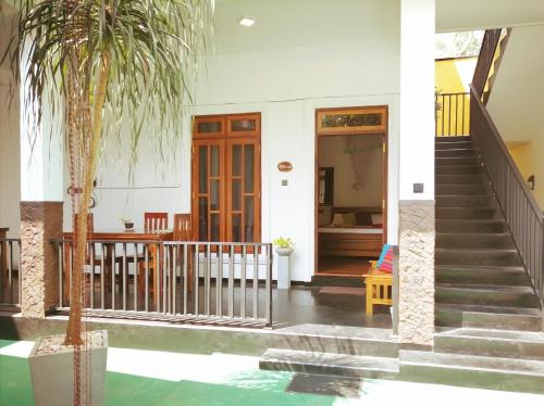 阿努拉德普勒Ceylonima Home Stay的房屋前方有楼梯和棕榈树