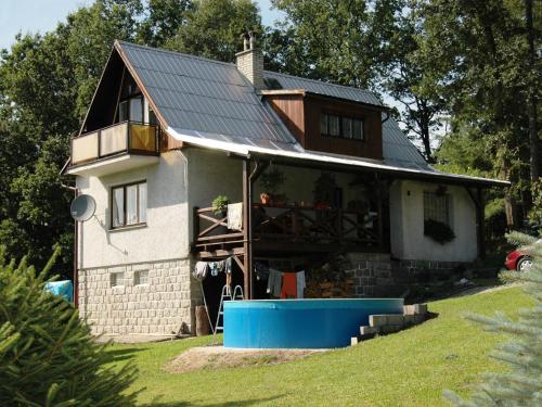 HnaniceHouse with the pool and fenced garden的顶部有金属屋顶的房子