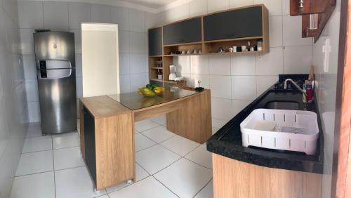 圣路易斯Rio Claro Comfort Hostel e Suítes的厨房配有带水槽的柜台和冰箱。