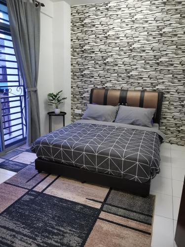 巴西古当Lavender Homestay @ Pasir Gudang的一间卧室设有一张床和砖墙
