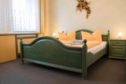 NieskyBürgerhaus Niesky的卧室内的绿色床和橙色枕头