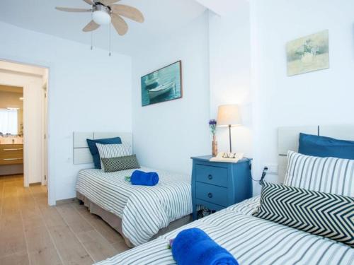 马拉加Holidays2Malaga Mendoza Terrace & Sea View的一间卧室配有两张床和吊扇