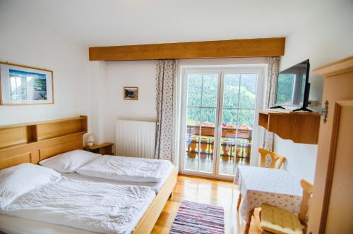 特雷芬Gästehaus Berger - Priglhof的一间卧室设有一张床和一个窗口