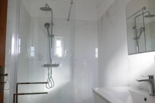 维拉摩拉Encosta das Oliveiras 49D的带淋浴和盥洗盆的白色浴室
