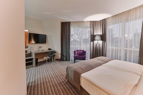 罗夫诺Boutique Hotel Central的配有一张床和一张书桌的酒店客房