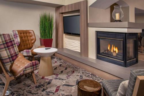 林夕昆高地巴尔的摩BWI机场居住馆酒店的客厅设有壁炉和电视。