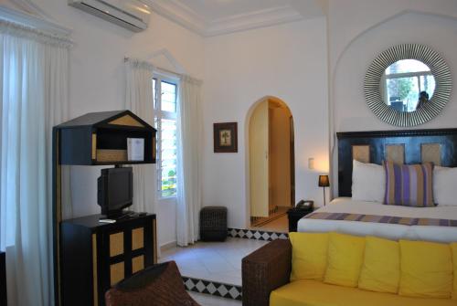 BijiloCoco Ocean Resort & Spa的一间卧室配有一张床、一把椅子和镜子