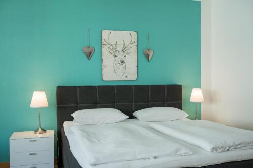 克桑滕努梅尔酒店的一间卧室设有一张蓝色墙壁的大床
