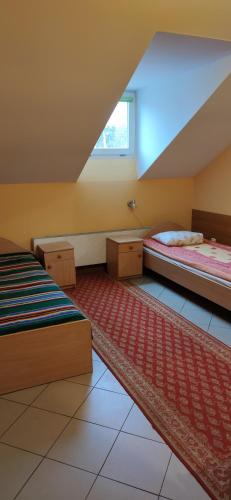 谢米亚蒂切Usługi hotelarskie Helena的阁楼卧室设有两张床和窗户。