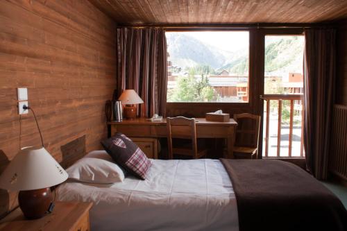 瓦勒迪泽尔科莱特酒店的一间卧室配有一张床、一张书桌和一个窗户。