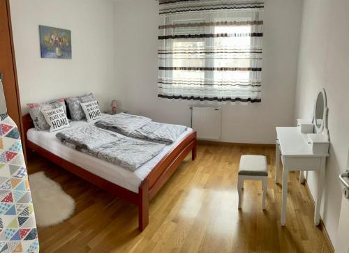 诺维萨德Paris apartment -Free private parking的一间卧室配有一张床、一张书桌和一个窗户。
