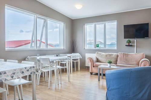 格仑达积图Stöð Guesthouse and apartments的用餐室设有桌椅和窗户。