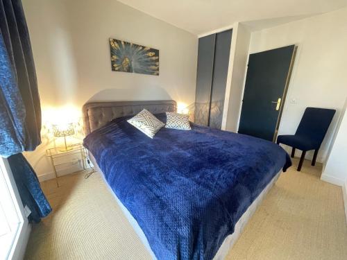 塞夫尔Blue Haven Sèvres的一间卧室配有蓝色的床和蓝色的毯子