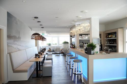 斯海弗宁恩Hotel Andante aan Zee的餐厅设有带凳子的酒吧