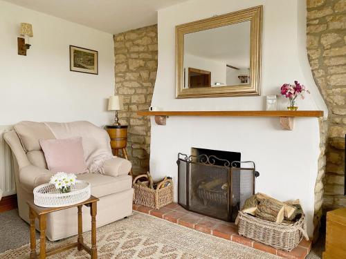 斯利福德Grange Farm Cottage的客厅配有椅子和壁炉