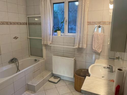 普克斯多夫Suburb Hostel的带浴缸、盥洗盆和卫生间的浴室