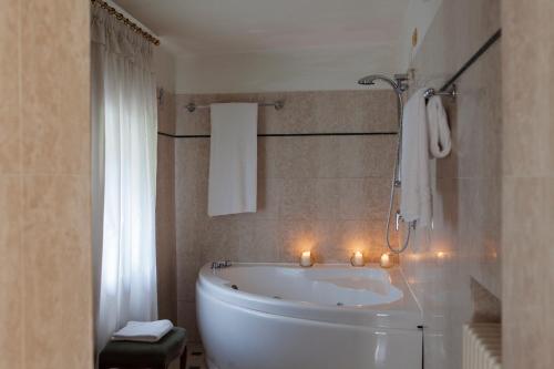 圣皮耶特罗因卡里亚诺吉奥纳别墅酒店的浴室设有白色的浴缸和蜡烛