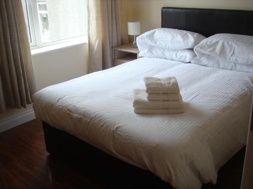 恩尼斯克朗Sun Apartments的一间卧室配有一张床,上面有两条毛巾